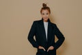 Attractive young model female in black suit with hair tied up in high bun