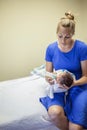 Young mother bottle feeding her newborn baby boy