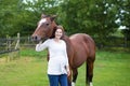 Attractive young pregnant woman and horse in field Royalty Free Stock Photo