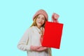 Attractive young red-haired girl with gift bags after shopping on a blue background looking towards the camera Royalty Free Stock Photo