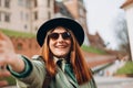 Attractive young Redhead female tourist is exploring new city. Traveling. Happy optimistic girl walking in city and Royalty Free Stock Photo