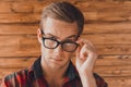 Attractive young serious man touching his glasses Royalty Free Stock Photo