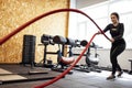 Attractive young slim and fit sportswoman working out in the gym for functional training doing crossfit exercises with battle Royalty Free Stock Photo