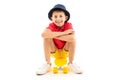 Attractive young smiling boy sitting on a yellow skateboard on a white background