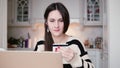 Attractive young smiling woman uses plastic credit card shopping online with laptop. Royalty Free Stock Photo