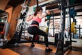 Attractive young sportswoman doing squats with barbell in gym Royalty Free Stock Photo