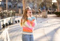Attractive young teenager woman talking and chatting on her smart phone outside in an European city Royalty Free Stock Photo