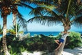 Young tourist man relaxing on palm tree on the caribbean beach Royalty Free Stock Photo