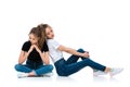 attractive young twins in jeans and shirts sitting on floor Royalty Free Stock Photo