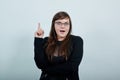 Attractive young unshaven woman in casual black dress showing on workspace Royalty Free Stock Photo