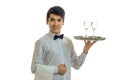 Attractive young waiter raised his hand tray with two glasses and smiling