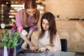 Attractive young waitress using a tablet computer to take an order from a customer in a coffee shop Royalty Free Stock Photo