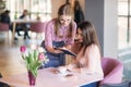 Attractive young waitress using a tablet computer to take an order from a customer in a coffee shop Royalty Free Stock Photo