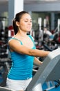 Attractive young woman adjusts the treadmill Royalty Free Stock Photo