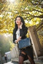 Attractive young woman in a autumnal fashion shot. Beautiful fashionable lady in black and white outfit posing in park Royalty Free Stock Photo