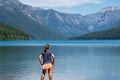 Attractive young woman with back facing camera looks at the scenery of Bowman Lake in Glacier National Park Montana Royalty Free Stock Photo