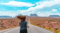 Attractive young woman from back view running in the middle of American straight road in the desert. Royalty Free Stock Photo