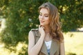 Attractive young woman with a beautiful smile in a fashionable summer vest in a white T-shirt posing outdoors against a background Royalty Free Stock Photo