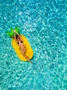 Woman in bikini relaxes on a pineapple shaped float in a pool Royalty Free Stock Photo