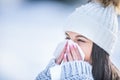 Attractive young woman blowing her nose with a tissue in winter Royalty Free Stock Photo