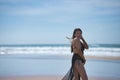 Attractive young woman, blue eyes, wearing black swimsuit and sarong, lonely and quiet, walking on the beach. Concept tranquility