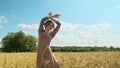 attractive young woman in brown dress walks along yellow field against blue sky with clouds. beautiful beauty lady spin Royalty Free Stock Photo