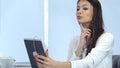 Attractive young woman checking her make up using tablet and preparing for video call Royalty Free Stock Photo