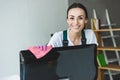 attractive young woman cleaning computer monitor and smiling Royalty Free Stock Photo