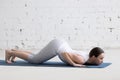 Attractive young woman doing Eight-Limbed yoga Pose in white loft