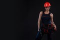 Attractive young woman doing repairs at black background. Portrait of a female construction worker. Building, repair concept. Copy Royalty Free Stock Photo