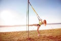 Attractive young  woman  doing TRX training outdoors near the lake at daytime. Healthy lifestyle Royalty Free Stock Photo