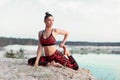 An attractive young woman doing a yoga pose for balance and stretching near the lake high in the mountains Royalty Free Stock Photo