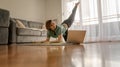 Attractive young woman doing yoga stretching yoga online at home. Self-isolation is beneficial, entertainment and education on the Royalty Free Stock Photo