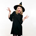 Attractive young woman dressed in witch halloween costume isolated over white background. Sensual Halloween Witch. Royalty Free Stock Photo