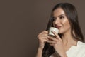 Attractive young woman drinking coffee on brown background Royalty Free Stock Photo