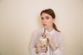 Attractive young woman drinking coffee latte from glass with straw Royalty Free Stock Photo