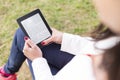 Attractive young woman with e-book/tablet in the park