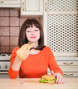 Attractive young woman eating french bread pizza and burger Royalty Free Stock Photo