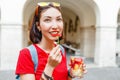 Young woman eating fresh fruit salad while walking through the historic center of the European city Royalty Free Stock Photo