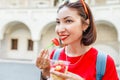 Young woman eating fresh fruit salad while walking through the historic center of the European city Royalty Free Stock Photo