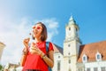 Young woman eating fresh fruit salad while walking through the historic center of the European city Royalty Free Stock Photo