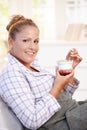 Attractive young woman eating yoghurt in bed Royalty Free Stock Photo