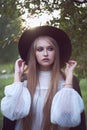 Attractive young woman enjoying her time outside in park in trees in background