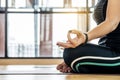 Attractive young woman exercising and sitting in yoga Lotus pose with mudra gesture position while resting at home, Royalty Free Stock Photo