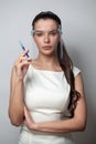 Attractive young woman in face shields holds syringe on white background, portrait Royalty Free Stock Photo