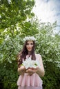 Attractive young woman in flowers wreath in spring blossom garden outdoors. Beautiful girl outdoor portrait Royalty Free Stock Photo