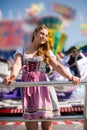 Attractive young woman at German funfair Oktoberfest with traditional dirndl dress