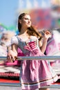 Attractive young woman at German funfair Oktoberfest with traditional dirndl dress