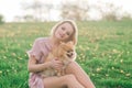 Attractive young woman holding dog spitz outside and smiling at camera, walking in the park Royalty Free Stock Photo