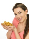 Attractive Young Woman Holding A Handful Of Salted Pretzels